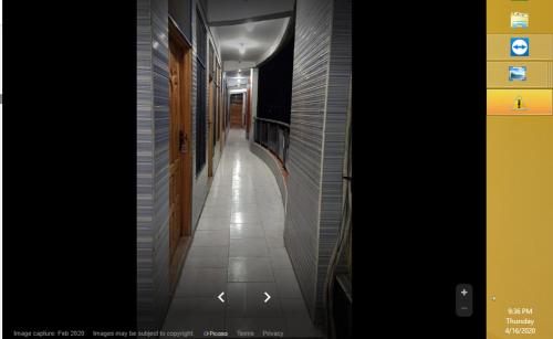 a hallway with a tile floor and a hallway with at Riverside Hotel in Mām Derai
