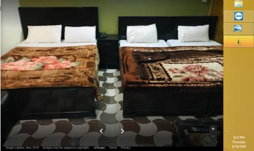dwa łóżka siedzące obok siebie w pokoju w obiekcie Riverside Hotel w mieście Mām Derai