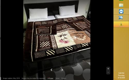 a bed with a blanket on top of it at Riverside Hotel in Mām Derai