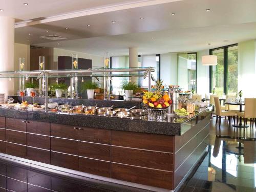 
a restaurant kitchen with a lot of food on the counter at Mercure Hotel Hagen in Hagen
