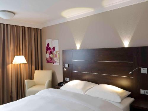 
a hotel room with two beds and a lamp at Mercure Hotel Hagen in Hagen
