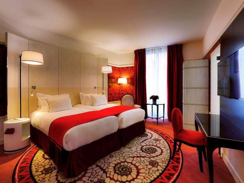 a hotel room with a large bed and two lamps at Hotel Carlton Lyon - MGallery Hotel Collection in Lyon