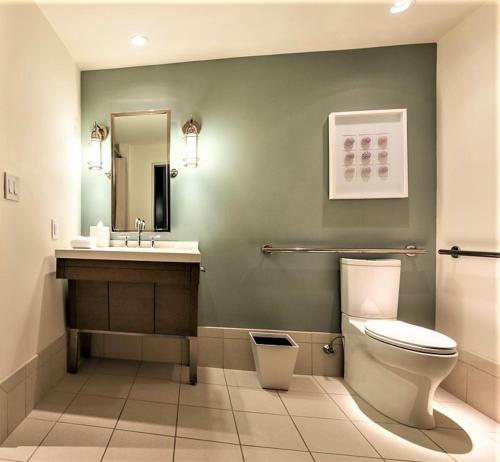 a bathroom with a toilet, sink, and mirror at Cliff House Maine in Cape Neddick
