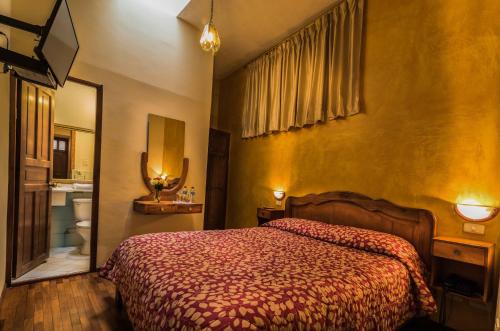 ein Hotelzimmer mit einem Bett und einem Bad in der Unterkunft Hotel San Francisco De Quito in Quito
