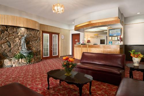 a lobby with a leather couch and a stone wall at Motel 6 Cornwall, ON in Cornwall
