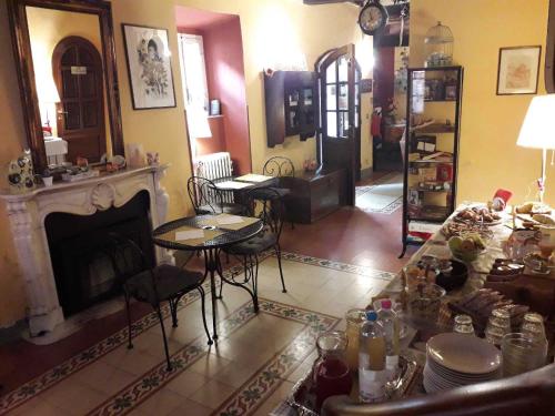 a living room with a fireplace and a table and chairs at Antica Casa Dei Rassicurati in Montecarlo