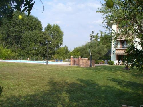a grassy field with a building and a building at Agriturismo Corte Trincerone in Mantova