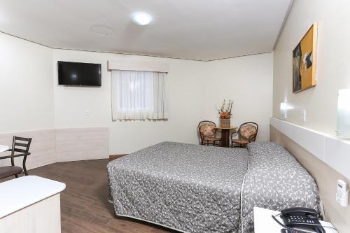a bedroom with a bed and a television in it at Hotel Express Centro Histórico in Porto Alegre