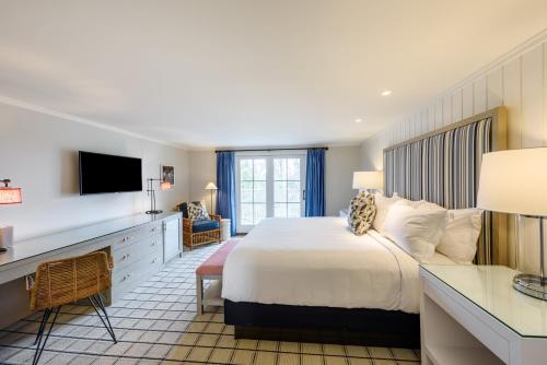 a hotel room with a bed and a desk at Harbor View Hotel in Edgartown