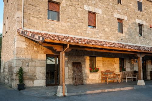 a stone building with awning on the side of it at Albergue turístico "La Fábrica" in Tardajos