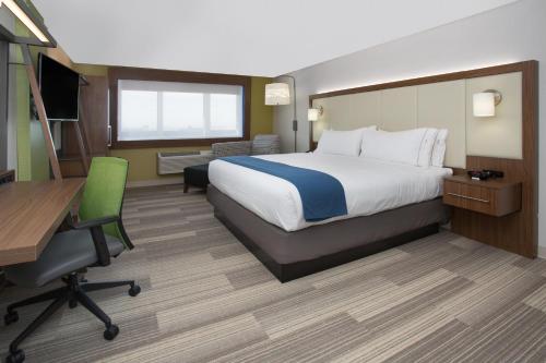 a hotel room with a bed and a desk and a computer at Holiday Inn Express & Suites - Grand Rapids South - Wyoming by IHG in Wyoming