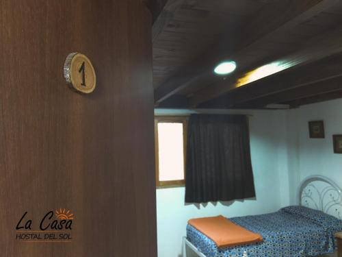 a bedroom with a bed and a clock on a wall at La casa de Hostal del Sol in Rosario