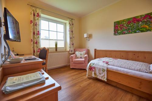 a bedroom with a bed and a desk at Flair Landhotel Strengliner Mühle in Pronstorf