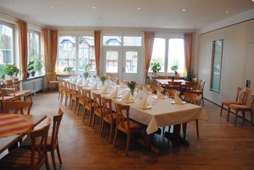a dining room with tables and chairs and windows at Flair Landhotel Strengliner Mühle in Pronstorf