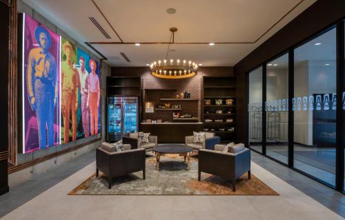 a lobby with couches and a table and chairs at Hotel Indigo Tulsa DWTN/Entertainment Area in Tulsa