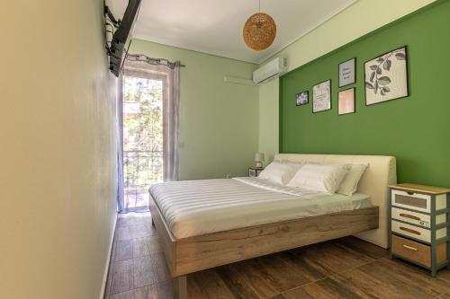 - une chambre avec un lit aux murs verts et une fenêtre dans l'établissement Bonnie & Clyde, à Kalamata
