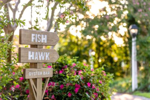 a sign that says fish and hawk in a garden at The Tides Inn in West Irvington
