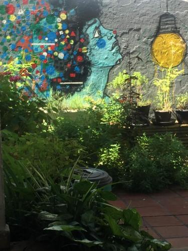 un jardín con plantas y una pintura en la pared en Espaço Colaborativo Coexistir, en São Paulo