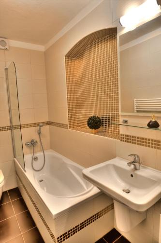 a bathroom with a sink and a bath tub at Hotel Peregrin in Český Krumlov