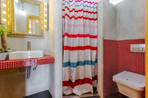 a bathroom with a red white and blue shower curtain at Villa Orange, small house in a pine forest in Kostrena