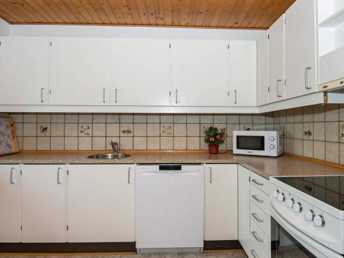 Kongsmarkにある4 person holiday home in R mのキッチン(白いキャビネット、電子レンジ付)