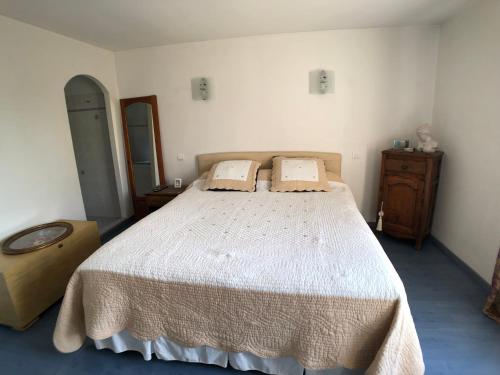 Un dormitorio con una gran cama blanca con dos almohadas. en Villa des Pies, en Fayence