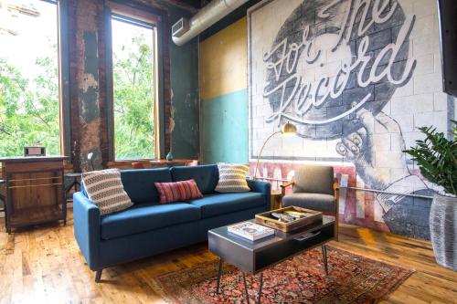 a living room with a blue couch and a mural at 506 Lofts in Nashville
