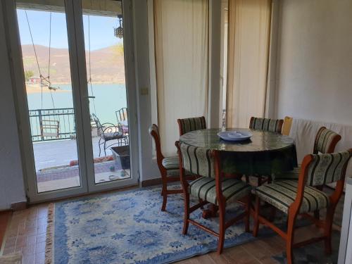 a dining room with a table and chairs and a balcony at Lake House in Novi Pazar