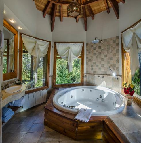 a large bathroom with a large tub and two sinks at Nido del Cóndor Hotel & Spa in San Carlos de Bariloche