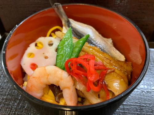 un tazón de comida con camarones y otras verduras en Dormy Inn Kurashiki Natural Hot Spring, en Kurashiki