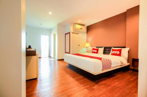 a bedroom with a large bed with red pillows at Super OYO 117 King One Suvarnabhumi in Bangkok