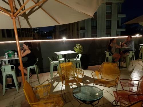 a group of people sitting at tables and chairs on a patio at Hostel Boutique Merced 88 in Santiago