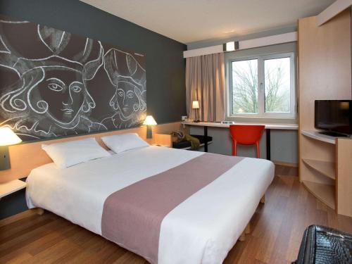 a hotel room with a bed and a painting on the wall at ibis Aalst in Aalst