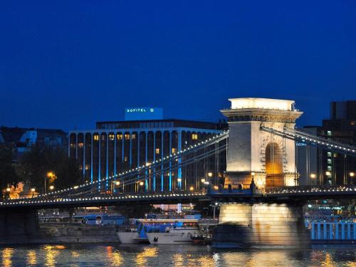 a bridge over a river at night with a building at Sofitel Budapest Chain Bridge in Budapest