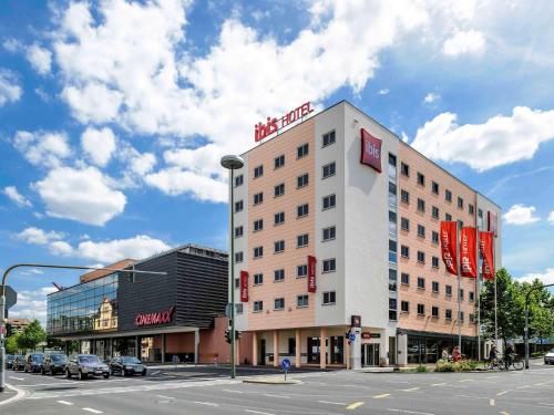 un bâtiment avec un panneau en haut d'une rue dans l'établissement ibis Hotel Würzburg City, à Wurtzbourg