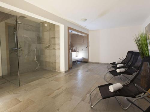 een badkamer met een douche en 2 stoelen en een glazen douchecabine bij Casa Bellanova in Nauders