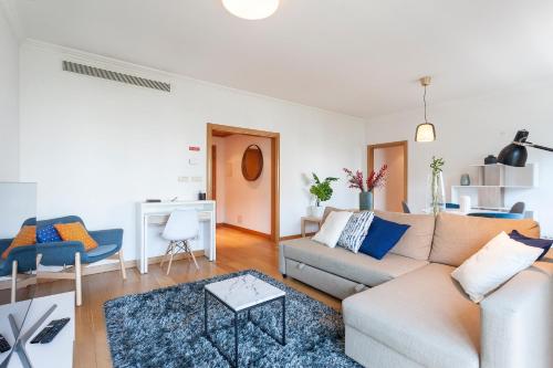 a living room with a couch and a table at Central Orient Residence - Modern, spacious and sunny! By the river! in Lisbon