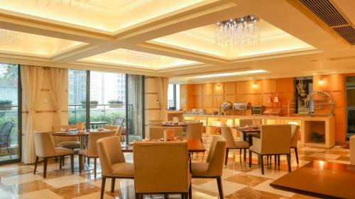a restaurant with tables and chairs and a kitchen at 广州丹顿行政公寓珠江新城店-广交会期间免费穿梭巴士 in Guangzhou