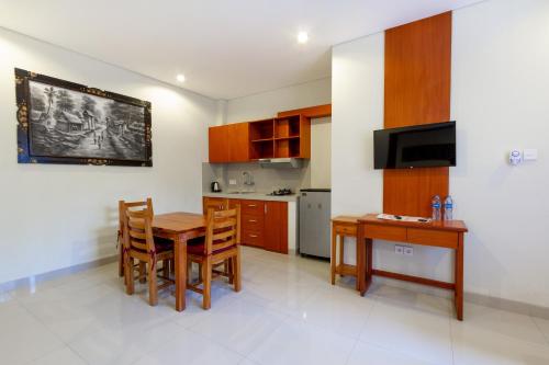 a kitchen with a wooden table and a dining room at Asoka Hotel & Suite in Sanur