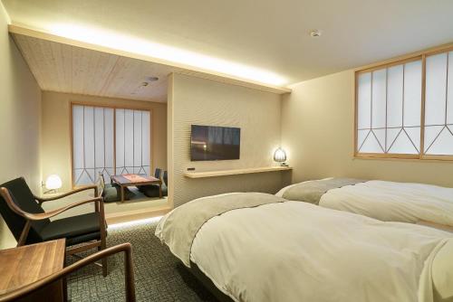 um quarto de hotel com duas camas e uma televisão em 凜庵 LIAN_KANAZAWA em Kanazawa