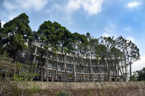 a building with trees in front of it at Sun Moon Lake Bamboo Rock Garden in Yuchi