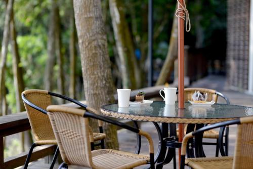 a table with two chairs and a table with cups on it at Sun Moon Lake Bamboo Rock Garden in Yuchi