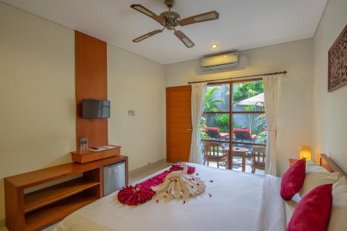 a bedroom with a white bed with red pillows at Asoka Hotel & Suite in Sanur