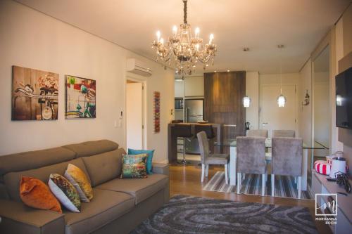a living room with a couch and a dining room at Apto Fofo in Gramado