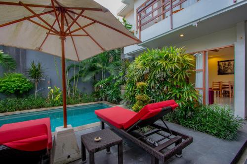 a chair and an umbrella next to a pool at Asoka Hotel & Suite in Sanur