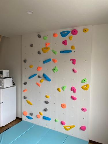 an indoor bouldering wall with colorful letters on it at Tiz wan 岩屋あわじ in Awaji