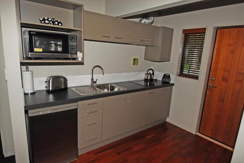 a kitchen with a sink and a microwave at Woodbank Park Cottages in Hanmer Springs