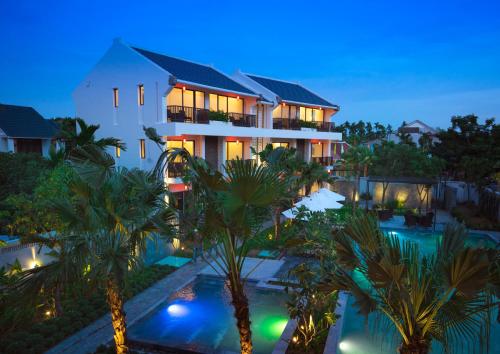 a villa with a swimming pool at night at SENVILA Boutique Resort & Spa in Hoi An