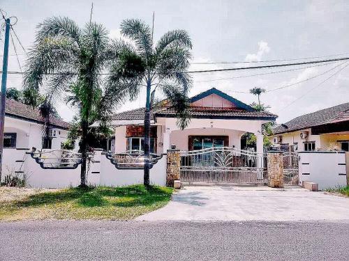 a house with two palm trees in front of it at Taiping Vacation Home in Taiping