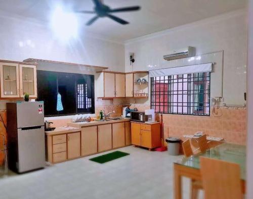 een keuken met een koelkast en een plafondventilator bij Taiping Vacation Home in Taiping